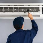 technician fixing a home's air conditioning unit