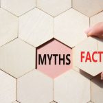 facts or myths symbol. concept word facts or myths on wooden comb puzzle. businessman hand. beautiful pink background. business and facts or myths concept.