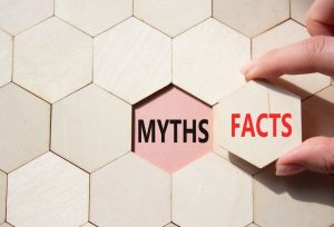 facts or myths symbol. concept word facts or myths on wooden comb puzzle. businessman hand. beautiful pink background. business and facts or myths concept.